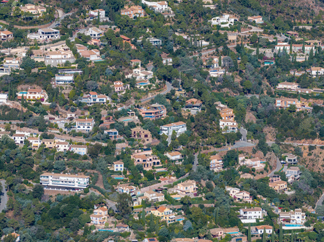 Aerial view of Le Trayas featuring numerous villas nestled among lush green trees and winding roads on a hillside in Saint Raphael Provence Alpes Cote d Azur France. Aerial view of Le Trayas featuring numerous villas nestled among lush green trees and winding roads on a hillside in Saint Raphael Provence Alpes Cote d Azur France.