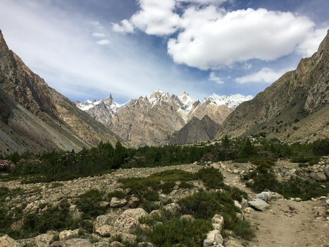 View of the Hushe River Valley with snow capped mountain peaks rocky terrain and green shrubs in Saling Gilgit Pakistan. View of the Hushe River Valley with snow capped mountain peaks rocky terrain and green shrubs in Saling Gilgit Pakistan.