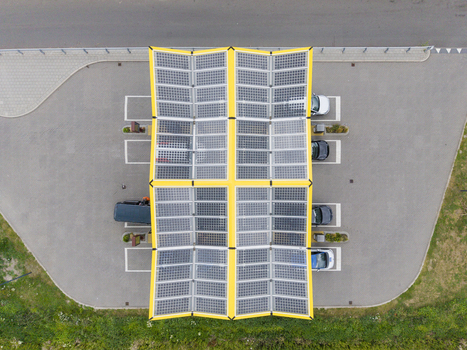 Aerial view of Fastned charging station with solar panel roof and parked electric vehicles in a paved lot in Breukelen Utrecht Netherlands. Aerial view of Fastned charging station with solar panel roof and parked electric vehicles in a paved lot in Breukelen Utrecht Netherlands.