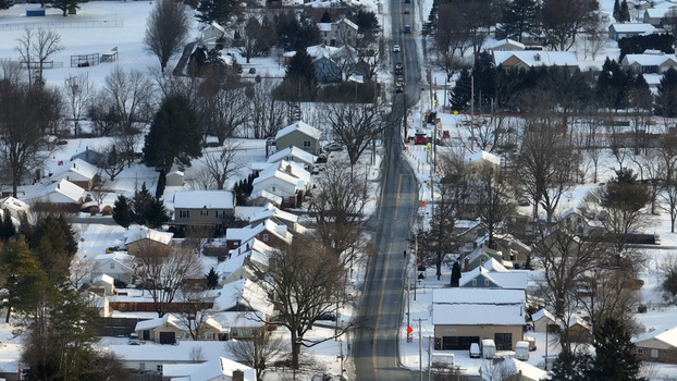 Aerial view of Sporting Hill covered in snow with residential houses snow covered rooftops and a main road running through the landscape in Hampden Township Pennsylvania United States. Aerial view of Sporting Hill covered in snow with residential houses snow covered rooftops and a main road running through the landscape in Hampden Township Pennsylvania United States.