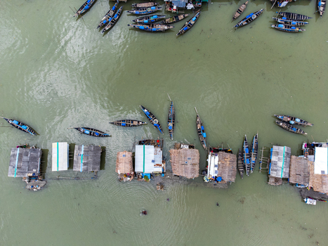 Aerial view of Kalabagi village with traditional wooden boats moored near stilted houses on the river in Khulna District Khulna Division Bangladesh.