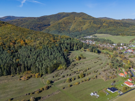 Aerial view of a picturesque valley flanked by mountains ablaze with autumn foliage contrasting with the neat red roofs of a tranquil village Klastor pod Znievom Zilina Region Slovakia. Aerial view of a picturesque valley flanked by mountains ablaze with autumn foliage contrasting with the neat red roofs of a tranquil village Klastor pod Znievom Zilina Region Slovakia.
