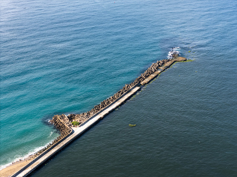 Aerial view of the Rio Ozama breakwater with concrete tetrapods extending into the Caribbean Sea at the river mouth in Santo Domingo Santo Domingo Dominican Republic.