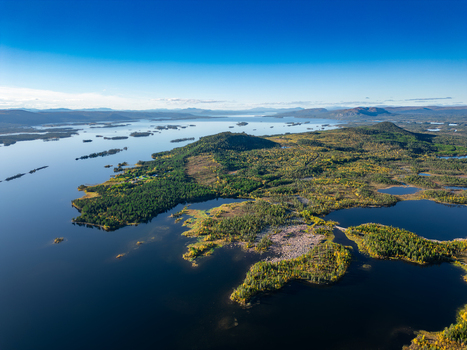 Aerial view of Galtispuoda mountain overlooking the vast lake system dense coniferous forests and scattered islands in the wilderness of Arjeplog Norrbotten County Sweden.