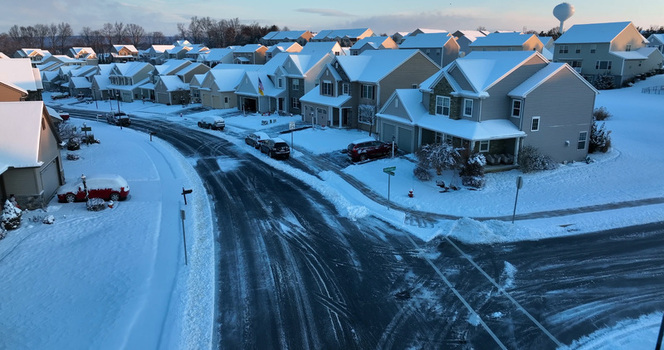 Aerial view of a quiet suburban neighborhood with snow covered houses and roads during a winter day in Manheim Pennsylvania United States.