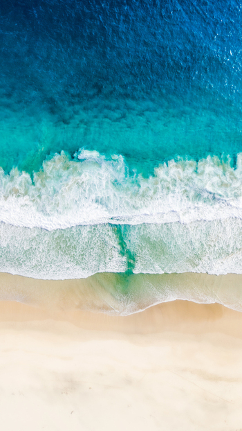 Aerial view of Modangan Beach with turquoise waves crashing on the sandy shore in Donomulyo East Java Indonesia. Aerial view of Modangan Beach with turquoise waves crashing on the sandy shore in Donomulyo East Java Indonesia.