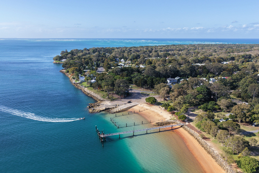 Aerial view of the jetty at Minjerribah North Stradbroke Island with turquoise waters of Moreton Bay sandy beaches and coastal vegetation Amity Point Queensland Australia. Aerial view of the jetty at Minjerribah North Stradbroke Island with turquoise waters of Moreton Bay sandy beaches and coastal vegetation Amity Point Queensland Australia.