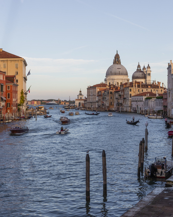 View of the Grand Canal with the Basilica di Santa Maria della Salute and traditional boats under a clear sky in Venice Veneto Italy. View of the Grand Canal with the Basilica di Santa Maria della Salute and traditional boats under a clear sky in Venice Veneto Italy.