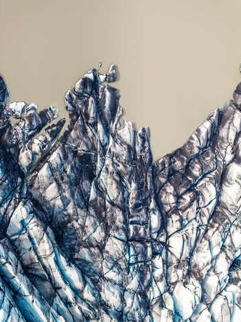 Aerial view of the intricate deep blue crevasses and textured ice formations of a glacier in Iceland. Aerial view of the intricate deep blue crevasses and textured ice formations of a glacier in Iceland.