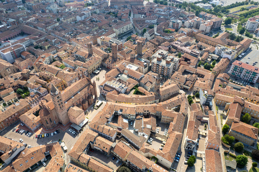 Aerial view of the historic center of Alba featuring the San Lorenzo Cathedral and medieval towers among red tiled rooftops Alba Piedmont Italy.