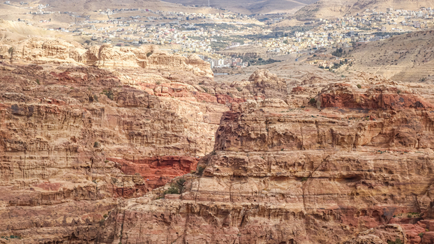 View of the rugged sandstone cliffs and desert landscape surrounding the town of Wadi Musa Ma an Governorate Jordan. View of the rugged sandstone cliffs and desert landscape surrounding the town of Wadi Musa Ma an Governorate Jordan.