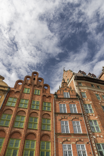 Gdansk Pomeranian Voivodeship Poland 07 September 2026 View of historic red brick buildings with ornate gables and green framed windows under a cloudy blue sky in the old town. Gdansk Pomeranian Voivodeship Poland 07 September 2026 View of historic red brick buildings with ornate gables and green framed windows under a cloudy blue sky in the old town.