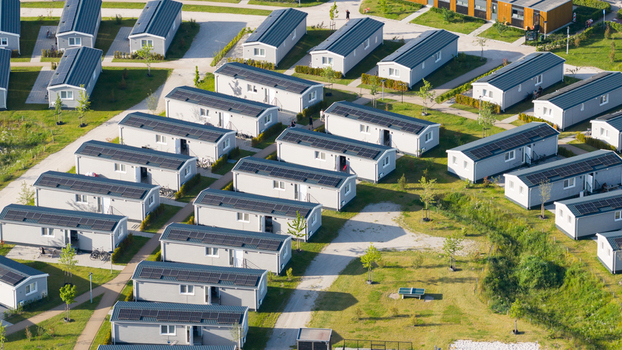 Aerial view of modern modular holiday homes with solar panels arranged in rows within a green park setting in Venlo Limburg Netherlands. Aerial view of modern modular holiday homes with solar panels arranged in rows within a green park setting in Venlo Limburg Netherlands.