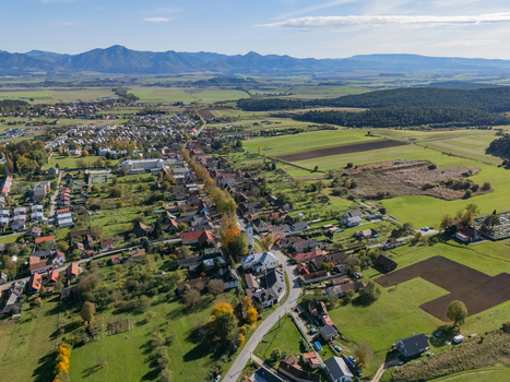 Aerial view of the charming village nestled amidst vibrant green fields and distant majestic mountains under a clear sky Klastor pod Znievom Zilina Region Slovakia. Aerial view of the charming village nestled amidst vibrant green fields and distant majestic mountains under a clear sky Klastor pod Znievom Zilina Region Slovakia.