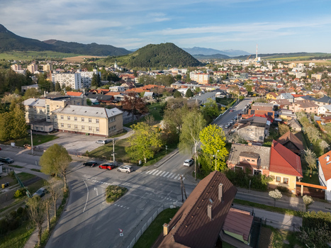 Aerial view of the town of Ruzomberok featuring residential houses lush green hills and distant mountains under a clear blue sky Ruzomberok Zilina Region Slovakia.