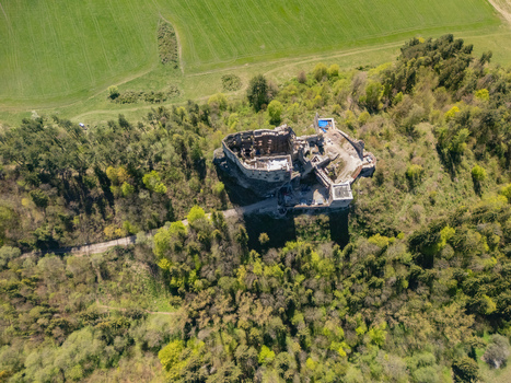 Aerial view of Castle Likava featuring ruined stone walls nestled within a lush green forest and surrounding agricultural fields Likavka Zilina Region Slovakia. Aerial view of Castle Likava featuring ruined stone walls nestled within a lush green forest and surrounding agricultural fields Likavka Zilina Region Slovakia.