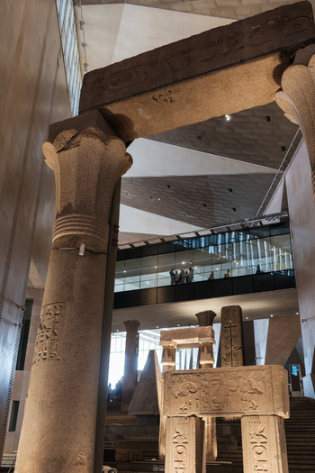 Giza Egypt 16 May 2026 View of the Grand Egyptian Museum featuring ancient stone columns with hieroglyphs and modern geometric architecture with a glass walkway.