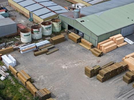 Melbourne Australia 25 September 2026 Aerial view of a lumber yard with stacks of timber industrial storage tanks and factory buildings.