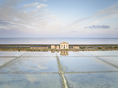 Aerial view of Saline dello Stagnone with historic salt pans reflective water pools and traditional buildings in Marsala Sicilia Italy. Aerial view of Saline dello Stagnone with historic salt pans reflective water pools and traditional buildings in Marsala Sicilia Italy.