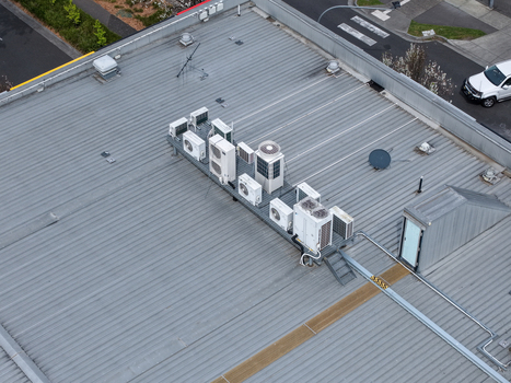 Melbourne VIC Australia 25 September 2026 Aerial view of a rooftop with multiple HVAC air conditioning units and ventilation systems on a corrugated metal roof.