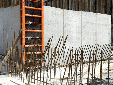 View of a concrete wall with orange formwork and vertical steel rebar at a construction site in Sariyer Istanbul Turkiye. View of a concrete wall with orange formwork and vertical steel rebar at a construction site in Sariyer Istanbul Turkiye.