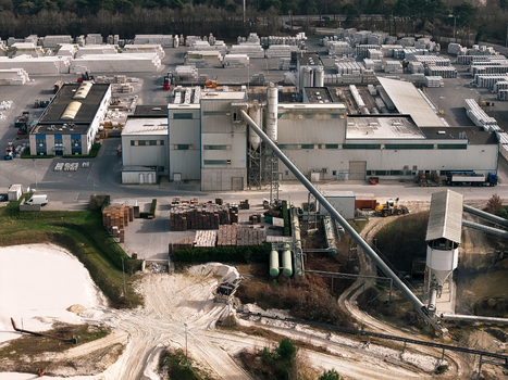 Aerial view of an industrial facility with large storage areas conveyor belts and processing buildings in a quarry setting in Dulmen North Rhine Westphalia Germany. Aerial view of an industrial facility with large storage areas conveyor belts and processing buildings in a quarry setting in Dulmen North Rhine Westphalia Germany.