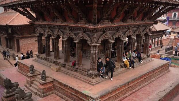 View of people sitting at a historic temple in Kathmandu Nepal.