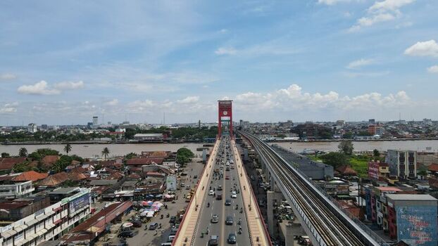 Aerial view of the iconic Ampera Bridge spanning the Musi River with heavy traffic and surrounding urban cityscape in Kecamatan Seberang Ulu I Sumatera Selatan Indonesia. Aerial view of the iconic Ampera Bridge spanning the Musi River with heavy traffic and surrounding urban cityscape in Kecamatan Seberang Ulu I Sumatera Selatan Indonesia.