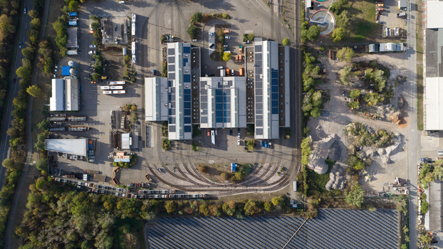 Aerial view of the Rhein Neckar Verkehr GmbH tram depot with solar panels on rooftops maintenance tracks and industrial infrastructure in Ludwigshafen am Rhein Rheinland Pfalz Germany. Aerial view of the Rhein Neckar Verkehr GmbH tram depot with solar panels on rooftops maintenance tracks and industrial infrastructure in Ludwigshafen am Rhein Rheinland Pfalz Germany.
