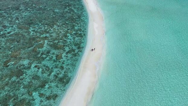 Aerial view of a narrow white sandbar with people in the ocean Maldives. Aerial view of a narrow white sandbar with people in the ocean Maldives.