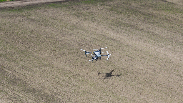 Aerial view of an agricultural drone spraying crops over a large tilled field in Zeewolde Flevoland Netherlands. Aerial view of an agricultural drone spraying crops over a large tilled field in Zeewolde Flevoland Netherlands.