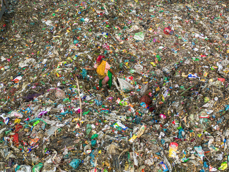 Aminbazar Bangladesh 26 January 2025 Aerial view of a woman scavenger walking through a vast expanse of colorful plastic waste and garbage at a landfill. Aminbazar Bangladesh 26 January 2025 Aerial view of a woman scavenger walking through a vast expanse of colorful plastic waste and garbage at a landfill.