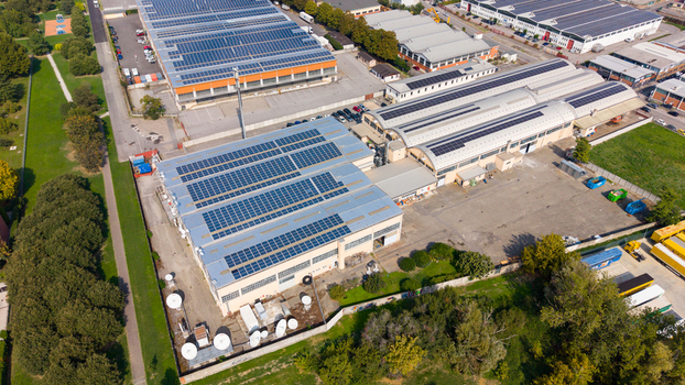 Aerial view of industrial buildings featuring extensive rooftop solar panel arrays in an industrial zone in Milan Lombardy Italy. Aerial view of industrial buildings featuring extensive rooftop solar panel arrays in an industrial zone in Milan Lombardy Italy.
