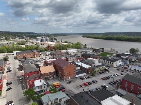 Aerial view of historic brick buildings and parking lots along the Ohio River under a cloudy sky in Aurora Indiana United States. Aerial view of historic brick buildings and parking lots along the Ohio River under a cloudy sky in Aurora Indiana United States.