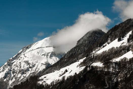 View of snow dusted peaks rise against a clear blue sky the cloud veiled summits creating a stunning alpine panorama Train from Lucerne to Interlaken Switzerland. View of snow dusted peaks rise against a clear blue sky the cloud veiled summits creating a stunning alpine panorama Train from Lucerne to Interlaken Switzerland.