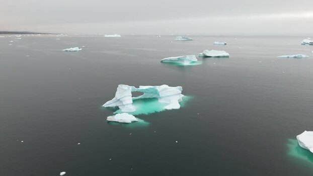 Aerial view of icebergs floating in the dark sea Greenland. Aerial view of icebergs floating in the dark sea Greenland.