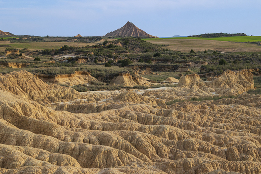 View of the unique semi desert landscape of Bardenas Reales with its eroded clay formations and rugged hills under a clear sky Navarre Spain. View of the unique semi desert landscape of Bardenas Reales with its eroded clay formations and rugged hills under a clear sky Navarre Spain.