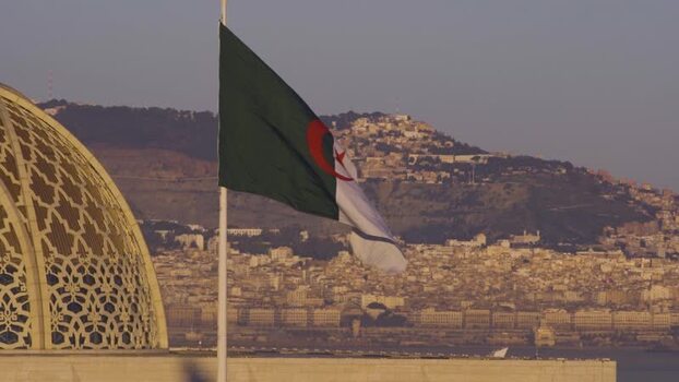Aerial view of Algerian flag near a mosque dome Algeria.