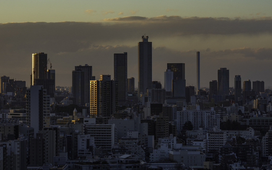 Aerial view of gold light kisses the faces of skyscrapers contrasting with the shadowed buildings below Bunkyo City Tokyo Japan. Aerial view of gold light kisses the faces of skyscrapers contrasting with the shadowed buildings below Bunkyo City Tokyo Japan.