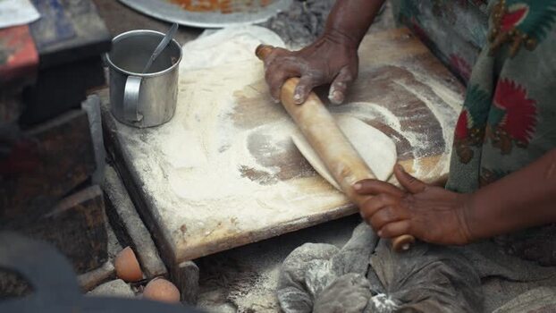 View of a woman rolling dough for flatbread in Bogura Bangladesh. View of a woman rolling dough for flatbread in Bogura Bangladesh.
