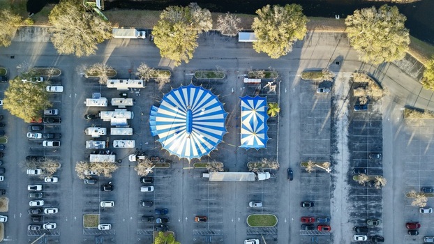 Aerial view of a vibrant blue and white striped tent and a smaller tent nestled in a parking lot near the St. Augustine Amphitheatre St. Augustine Florida United States. Aerial view of a vibrant blue and white striped tent and a smaller tent nestled in a parking lot near the St. Augustine Amphitheatre St. Augustine Florida United States.