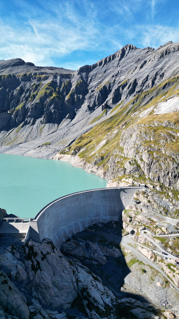 Aerial view of the Vieux Emosson Dam and its turquoise lake surrounded by rugged alpine mountains and rocky slopes in Finhaut Valais Switzerland. Aerial view of the Vieux Emosson Dam and its turquoise lake surrounded by rugged alpine mountains and rocky slopes in Finhaut Valais Switzerland.