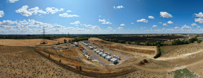 Aerial view of Eaton Socon Substation featuring battery energy storage systems and adjacent solar farm surrounded by agricultural fields and power lines in St. Neots England United Kingdom. Aerial view of Eaton Socon Substation featuring battery energy storage systems and adjacent solar farm surrounded by agricultural fields and power lines in St. Neots England United Kingdom.
