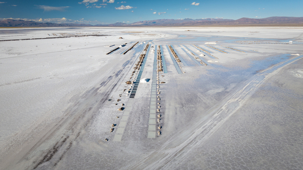 Aerial view of the Salinas Grandes salt flats featuring geometric salt extraction pools and vast white salt crust under a clear blue sky in La Poma Department Salta Province Argentina. Aerial view of the Salinas Grandes salt flats featuring geometric salt extraction pools and vast white salt crust under a clear blue sky in La Poma Department Salta Province Argentina.