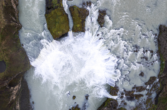 Aerial view of Godafoss Waterfall with powerful white water cascading over dark volcanic rocks and mossy cliffs Thingeyjarsveit Iceland. Aerial view of Godafoss Waterfall with powerful white water cascading over dark volcanic rocks and mossy cliffs Thingeyjarsveit Iceland.