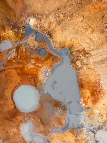 Aerial view of geothermal pools with milky blue water surrounded by vibrant orange and brown mineral deposits in the rugged volcanic landscape of Iceland. Aerial view of geothermal pools with milky blue water surrounded by vibrant orange and brown mineral deposits in the rugged volcanic landscape of Iceland.