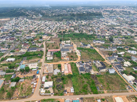 Aerial view of houses and vegetation interspersed with patches of bare earth creating a textured mosaic under a vast sky Umuahia Abia Nigeria. Aerial view of houses and vegetation interspersed with patches of bare earth creating a textured mosaic under a vast sky Umuahia Abia Nigeria.