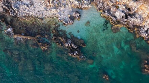 Aerial view of rocky coastline and turquoise water in Albania.