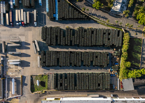 Aerial view of the beer industrial complex featuring organized rows of crates transport trucks and storage facilities in Santo Domingo Dominican Republic. Aerial view of the beer industrial complex featuring organized rows of crates transport trucks and storage facilities in Santo Domingo Dominican Republic.