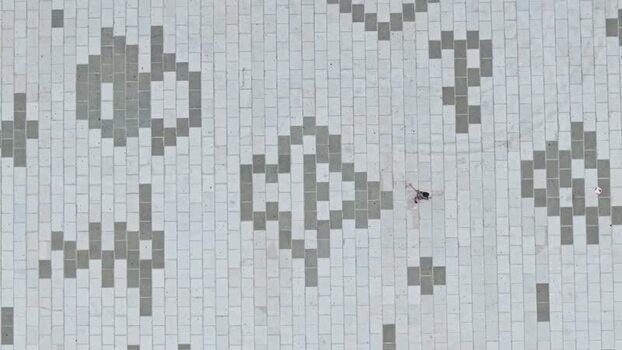 Aerial view of a person walking on a patterned stone square Albania. Aerial view of a person walking on a patterned stone square Albania.